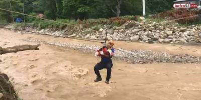 Çöken yol sebebiyle mahsur kalan 7 kişilik aile, halatlarla kurtarılıyor